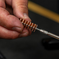 Product lifestyle image of Shooter's Choice .45cal bronze brush being threaded onto pistol cleaning rod