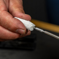 Product lifestyle image of Shooter's Choice .45cal bore mop being threaded onto a pistol cleaning rod