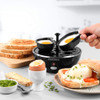 Black electric egg cooker with transparent lid, countertop product photo.