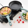 Double hot plate with a saucepan of cooked rice and vegetables, and empty frying pan