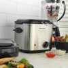 Stainless steel deep fryer on kitchen counter next to ceramic casserole dishes.