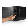 Hand adjusting dial on black microwave oven, showing timer and power settings.