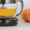 Glass Progress juicer jug with fresh orange juice, next to whole oranges.