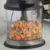Chopper bowl filled with diced mixed vegetables on kitchen worktop
