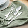 Four-piece silver cutlery set with knife, fork, tablespoon and teaspoon on table