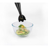 Black stick blender attachment held above clear glass bowl with avocado and herbs