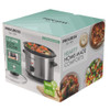 Silver electric slow cooker with stew inside, on kitchen counter next to bread and chopping board