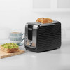 Black 2-slice toaster with wavy design, hand lowering lever, seeded bread inside
