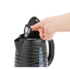 Black electric kettle with removable mesh filter, shown with hand lifting filter out.