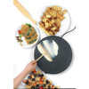 Electric crepe maker with a wooden spreader, shown cooking crepes with fruit and nut toppings