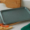 Green textured non-stick baking tray on kitchen counter