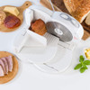 White food slicer in use with cooked meat and cheese platter in background