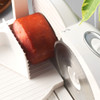 Electric food slicer cutting block of ham, focus on blade and meat tray