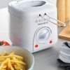 White Progress deep fryer on kitchen counter, shown beside a bowl of cooked chips.