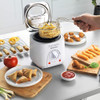 White Progress deep fryer on kitchen counter, shown beside a bowl of cooked chips.