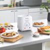 White Progress deep fryer on kitchen counter with plates of assorted fried food.