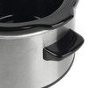 Stainless steel slow cooker close-up showing black handle and rim