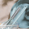 Set of two mint green Progress kitchen utensils, whisk and spatula, in mixing bowl.