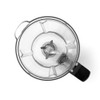Top view of a clear blender jug with stainless steel blades, shown empty against white.