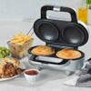 Electric pie maker with two golden pies cooking, on a kitchen counter.