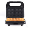Black waffle maker with two square golden waffles on the hot plate