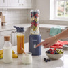 Blue personal blender with smoothie bottle, fruit and yoghurt on kitchen counter