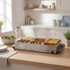 Electric warming tray with silver surface, black handles and adjustable heat control