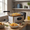 Stainless steel deep fryer on kitchen worktop with chips in frying basket