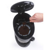 Coffee maker with open lid, hand adding ground coffee to filter