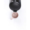 Black electric kettle pouring hot water into pale pink mug, product demo