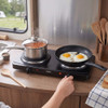 Double hot plate with pan of baked beans and frying pan cooking two eggs