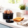 Egg boiler with six eggs on kitchen counter, next to toast and mug