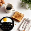 Non-stick egg poaching tray with one cooked egg, shown from above on white background