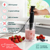 Black hand blender on counter beside tomatoes and soup pot, for blending sauces or soups.