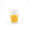 Clear measuring jug half-filled with orange liquid, shown on white background