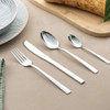 Four-piece silver cutlery set shown laid out on a table, includes fork, knife and two spoons