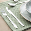 Three-piece silver cutlery set with striped bowl and plate on green napkin