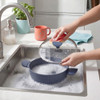 Set of three blue non-stick pans and lidded saucepan on kitchen counter, modern style