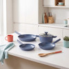 Glass saucepan lid with blue handle, shown from above.
