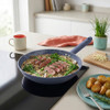 Blue non-stick frying pan with steak, broccoli and mushroom sauce on induction hob