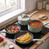 Green non-stick frying pan with omelette, shown being served onto plate