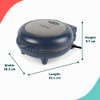 Electric omelette maker open on kitchen counter with eggs, cheese, and prepared ingredients.