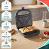 Open blue sandwich toaster with two toasted sandwiches and feature highlights