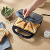 Open blue sandwich maker with non-stick plates, shown empty on white background