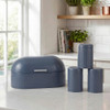 Blue bread bin with matching tea, coffee, and sugar canisters on kitchen counter