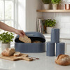 Set of three blue kitchen canisters for tea, coffee and sugar on white countertop