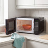 Black microwave with open door showing a bowl of soup on the turntable, in a modern kitchen.