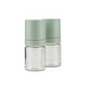 Set of two green manual spice grinders with glass base, one upright and one on its side.