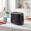 Black 2-slice toaster with wood accents on white kitchen worktop