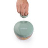 Green manual food chopper with pull cord in use, dicing vegetables